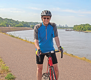 Man posing on a bike on the Mississippi River Greenway.