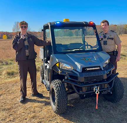 Two officers posing with an ATV.