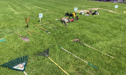 Garden tools laying in the grass.