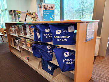 Book group kits on a shelf.