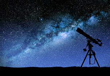 Silhouette of a telescope with a star-silled sky in the background..