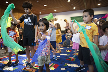 Children waving scarves at a library storytime.