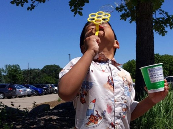 Child blowing bubbles at a celebration event.