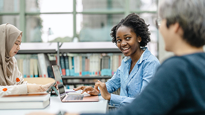 Teen girl sitting at a laptop.