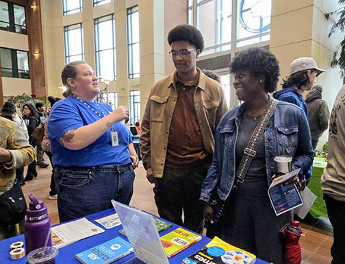A mother and son talking to a representative at the Teen Job Fair.