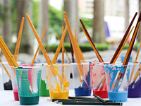 Cups filled with paint and brushes.