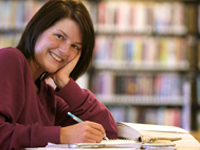 Woman smiling while reading a book.