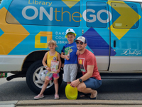 Man with three kids in front of the On the Go Van.
