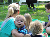 Infant boy being held by his mother at an outdoor storytime