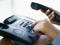 Close up of person dialing a telephone.