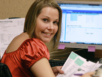 Woman smiling while at a computer.