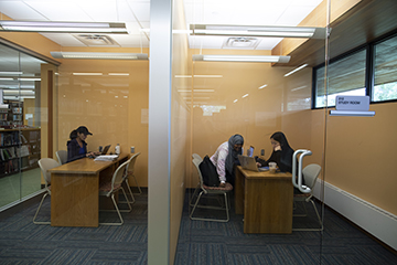 Two study rooms with people sitting at tables.