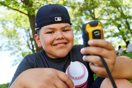 Childing holding GPS device and smiling.