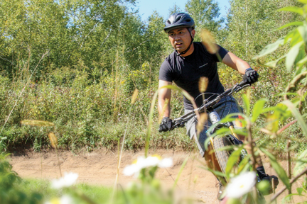 Man taking a turn on his mountain bike at the West Trailhead.