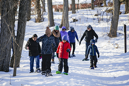 Group of people snowshoeing down a trail.