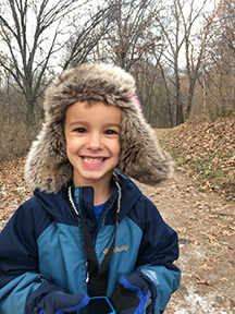 Child smiling on a late fall day.