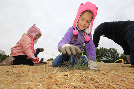 Two children planting grasses at a Public Lands Day event.