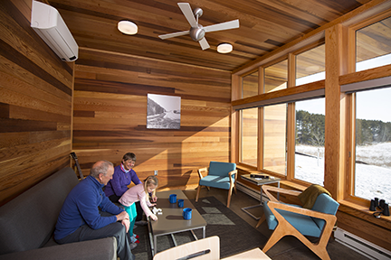 Family sitting on the couch at a Prairie View Cabin.