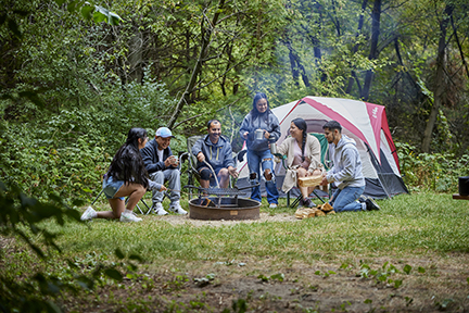 Family sitting around a campfire.