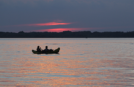 Two canoers on Lake Byllesby with the sunset in the background. 