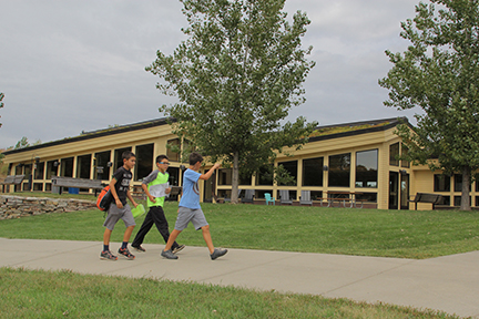 Three boys walking in front of the Visitor Center.