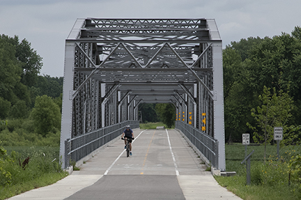 Biker going over a bridge on the Minnesota River Greenway.