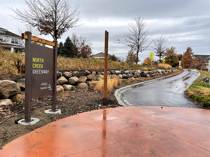 A North Creek Greenway sign on a rainy day.
