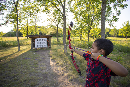 Child archer shooting at a target.