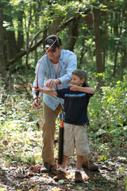 Father and son shooting a bow.