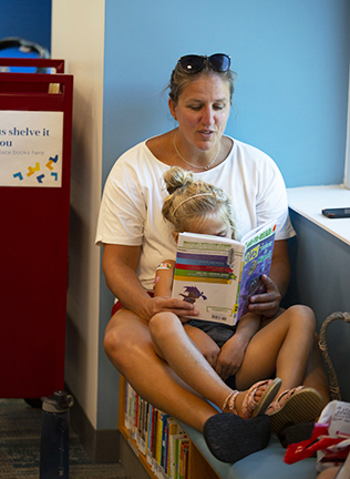 Woman reading a book to a child.