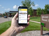 Hand holding smartphone with mobile app on the screen.
